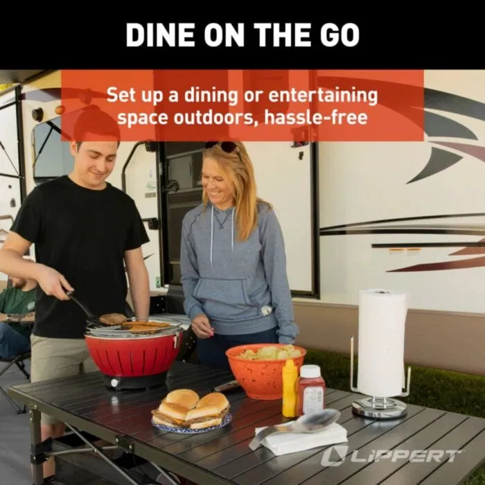 Two people grill burgers at a portable outdoor table, showcasing a simple and effective outdoor dining setup.